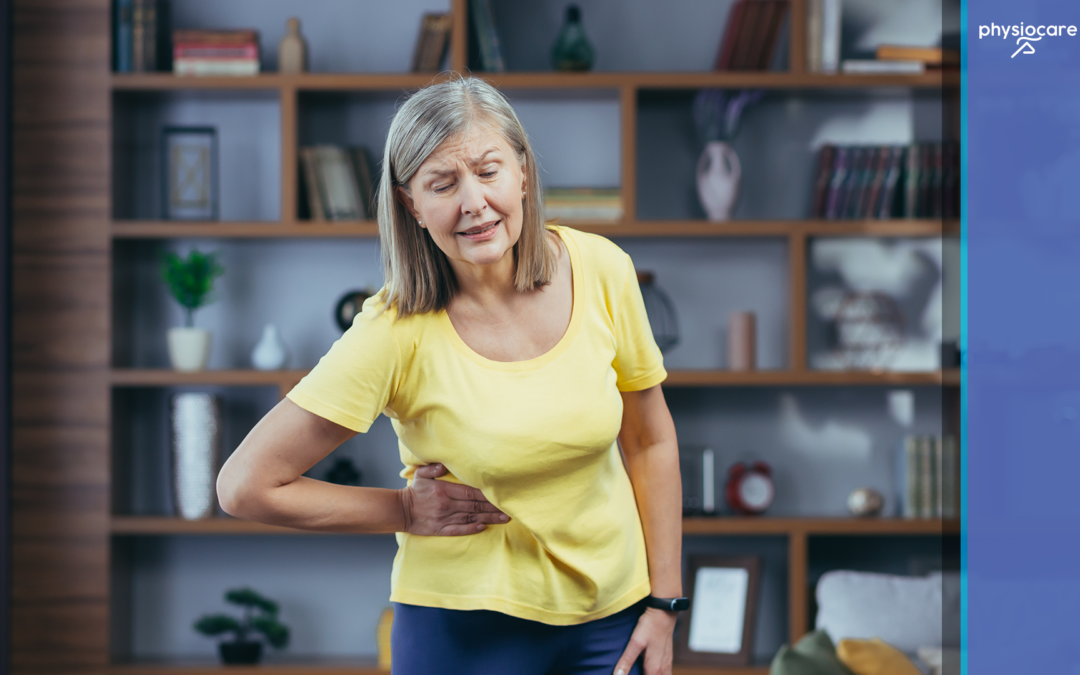 Woman holding her lower back while experiencing hip pain at home