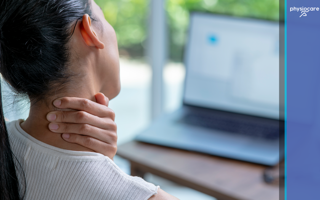Woman holding her neck while sitting at a computer due to neck pain