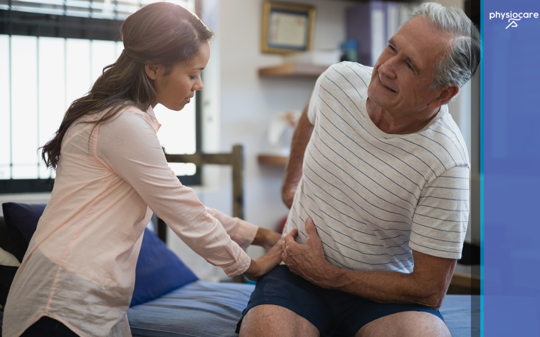 Physiotherapist examining a man with sacroiliac joint pain during a physiotherapy session