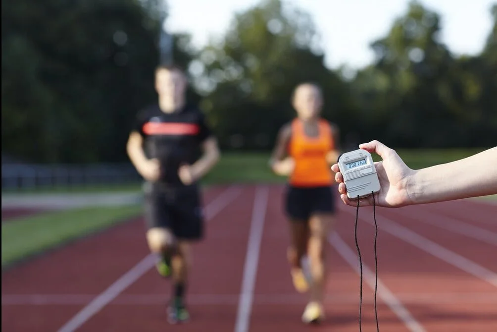 Male and female athletes running on track during biomechanical analysis